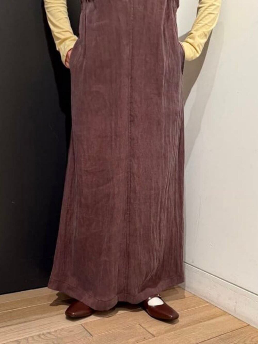 ブラウン系のワンピース、ベージュ系のTシャツ/カットソー、ホワイト系のハンドバッグを着用したレディースの春コーディネートの3枚目の写真