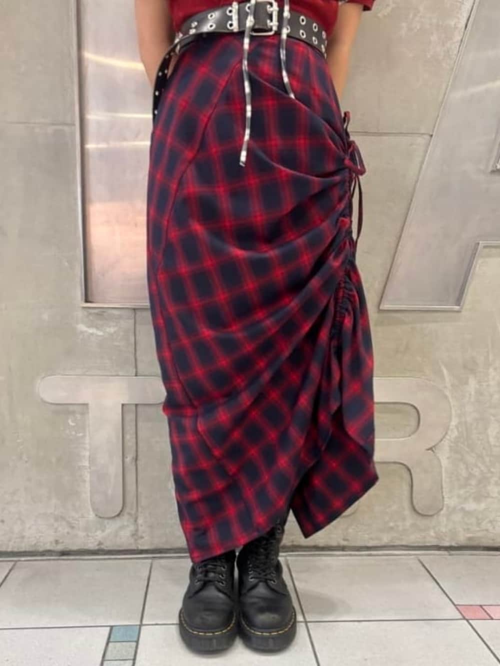 レッド系のスカート、レッド系のポロシャツを着用したレディースの夏コーディネートの3枚目の写真