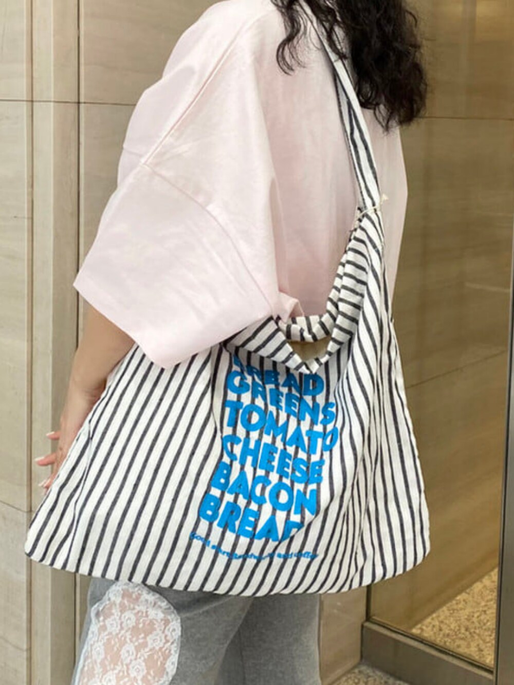 ピンク系のTシャツ/カットソー、グレー系のその他パンツ、ホワイト系のトートバッグを着用したレディースの春コーディネートの4枚目の写真