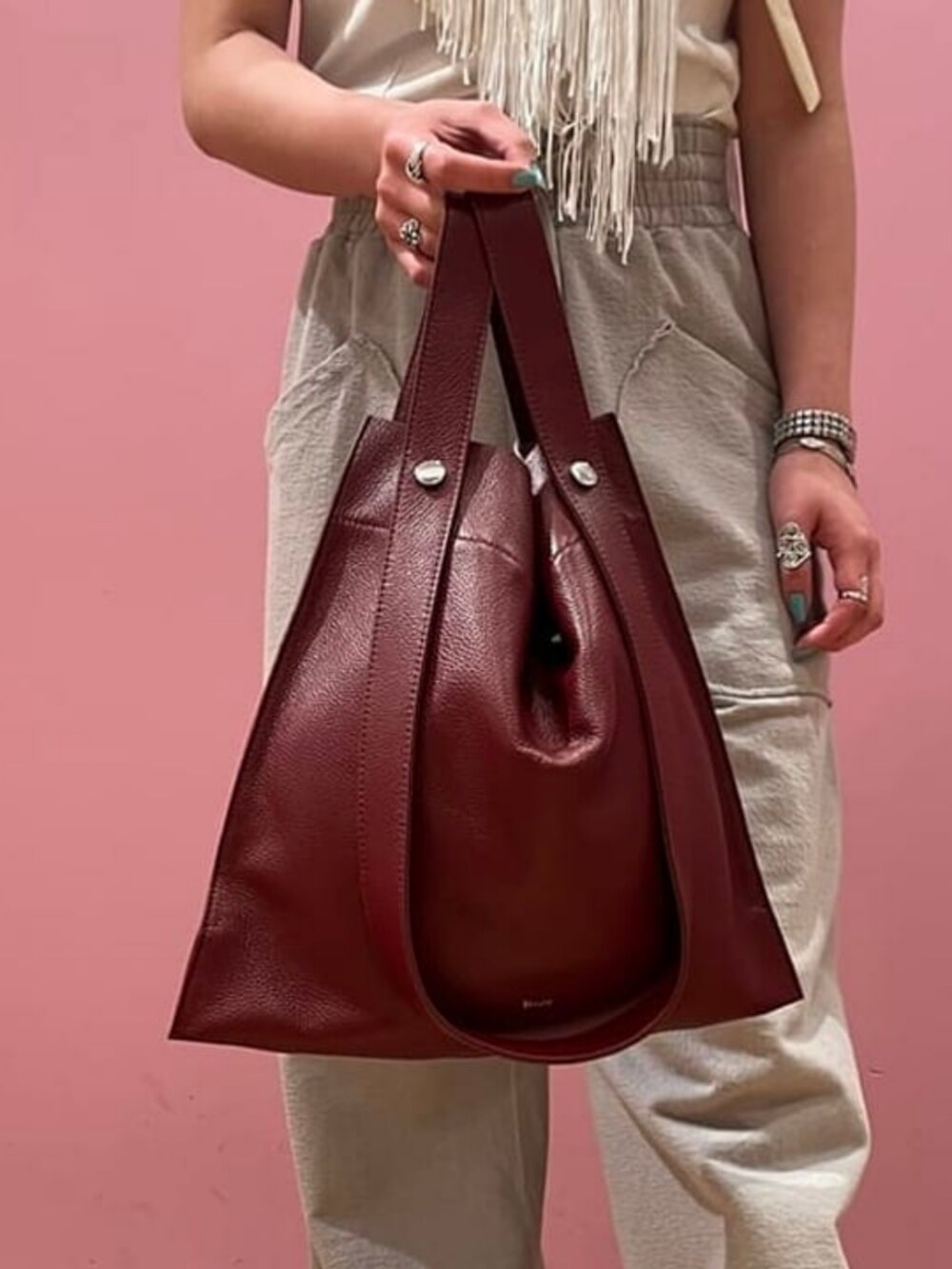 レッド系のトートバッグ、ホワイト系のTシャツ/カットソー、ホワイト系のスカートを着用したレディースの春コーディネートの2枚目の写真