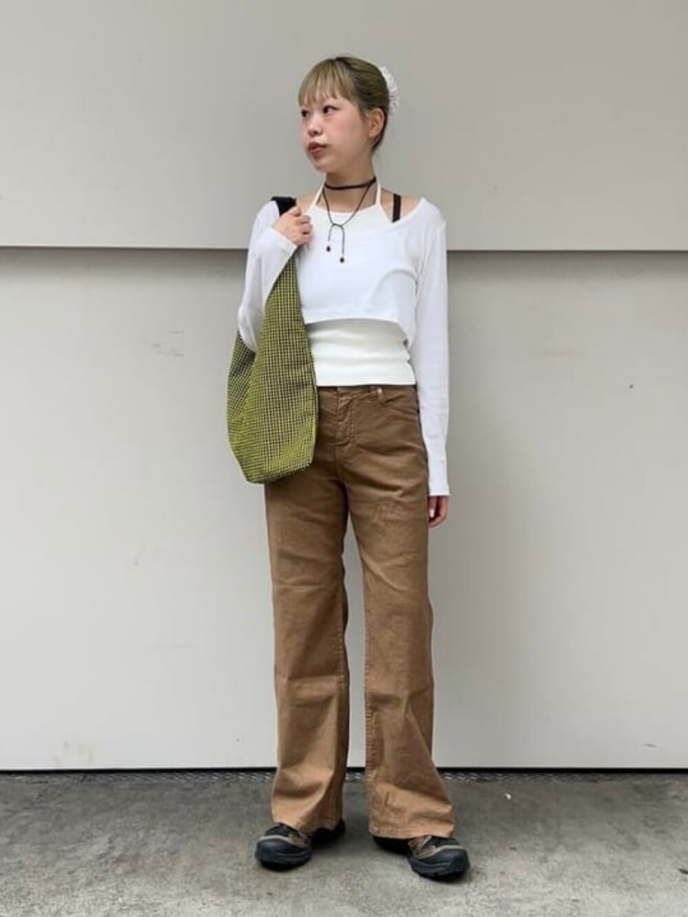 イエロー系のトートバッグ、ブラウン系のデニムパンツを着用したレディースの夏コーディネートの2枚目の写真