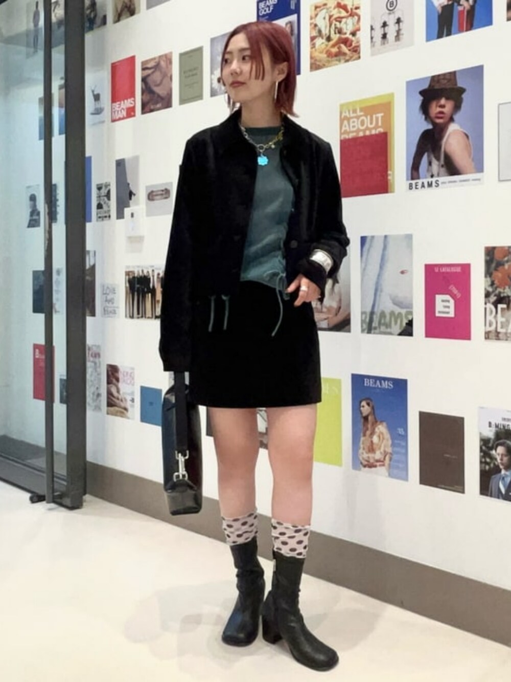 ブラック系のトートバッグ、ブルー系のTシャツ/カットソー、ブラック系のテーラードジャケットを着用したレディースの夏コーディネートの2枚目の写真