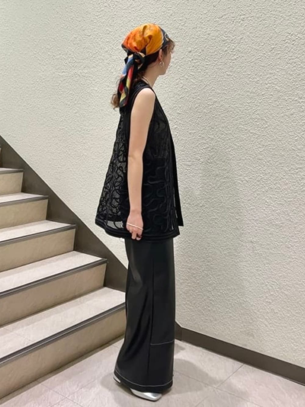 ベージュ系のタンクトップ、ブラック系のベスト、ブラック系のその他パンツを着用したレディースの春コーディネートの2枚目の写真