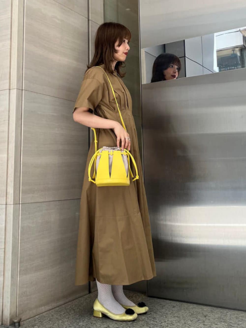 ブラウン系のワンピース、ブラック系のショルダーバッグを着用したレディースの夏コーディネートの2枚目の写真