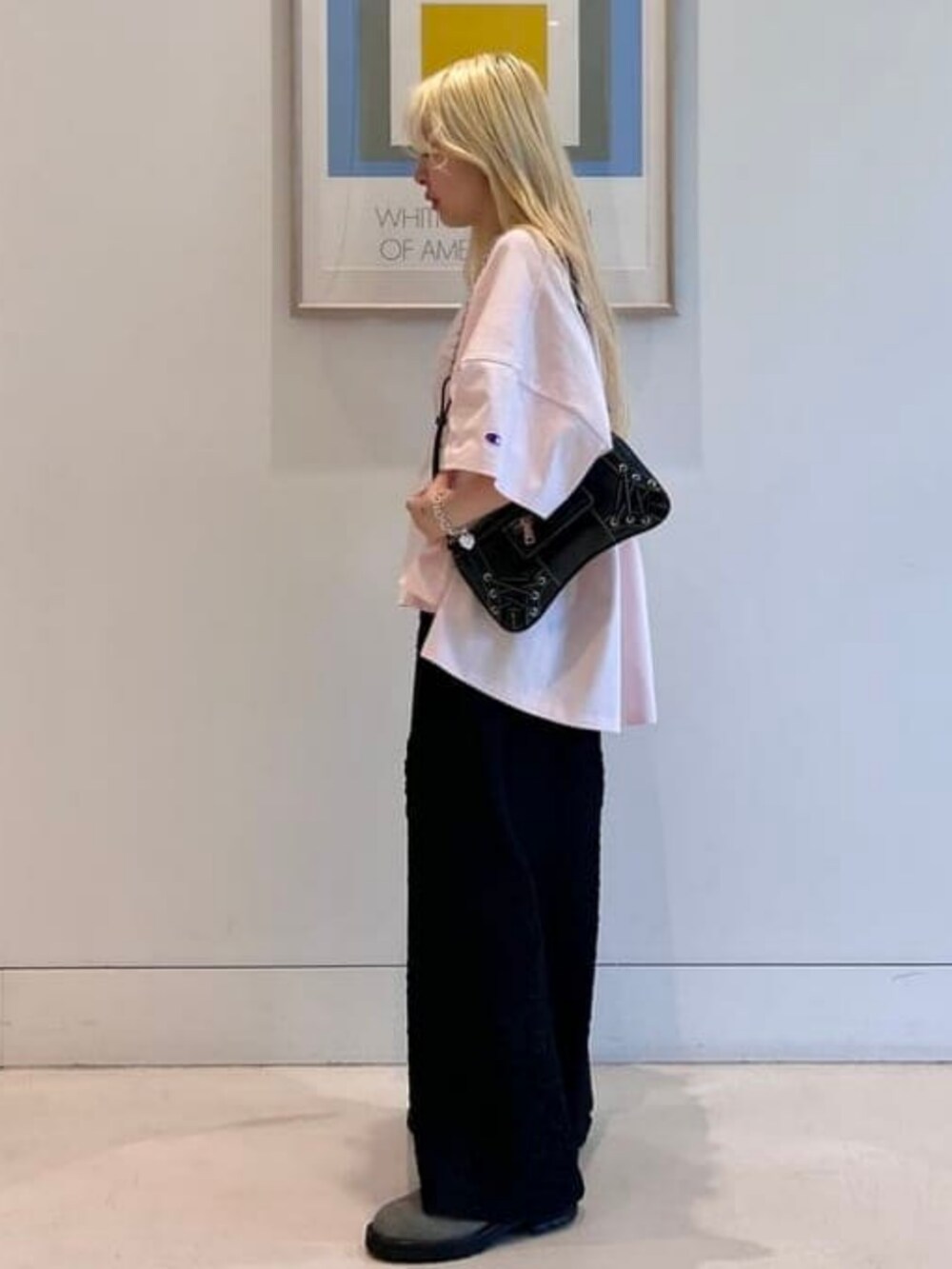 ブラック系のショルダーバッグ、ピンク系のTシャツ/カットソー、ブラック系のスカートを着用したレディースの春コーディネートの2枚目の写真