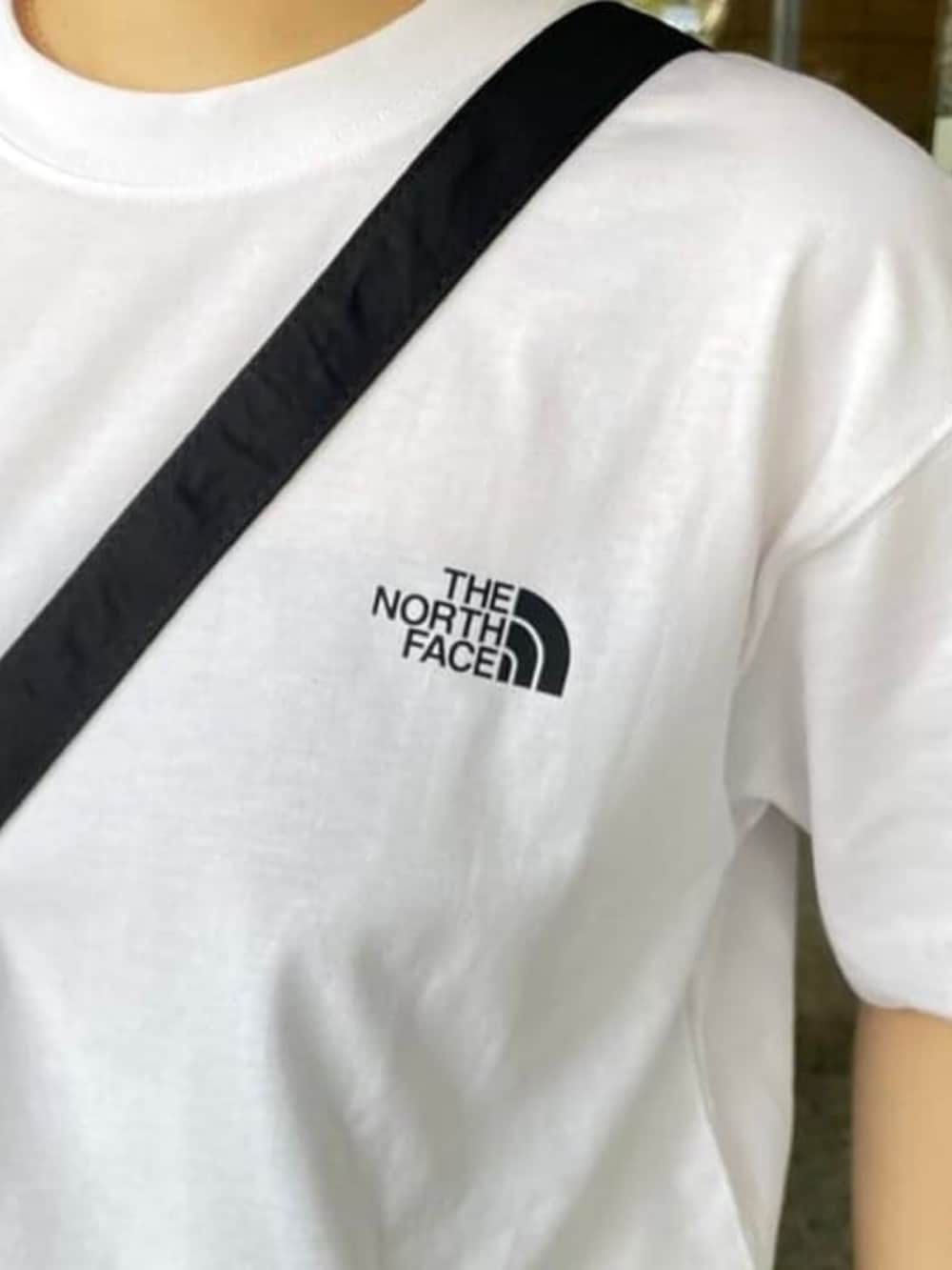 ホワイト系のスカート、ブラック系のトートバッグ、ブラック系のスニーカーを着用したレディースの春コーディネートの3枚目の写真