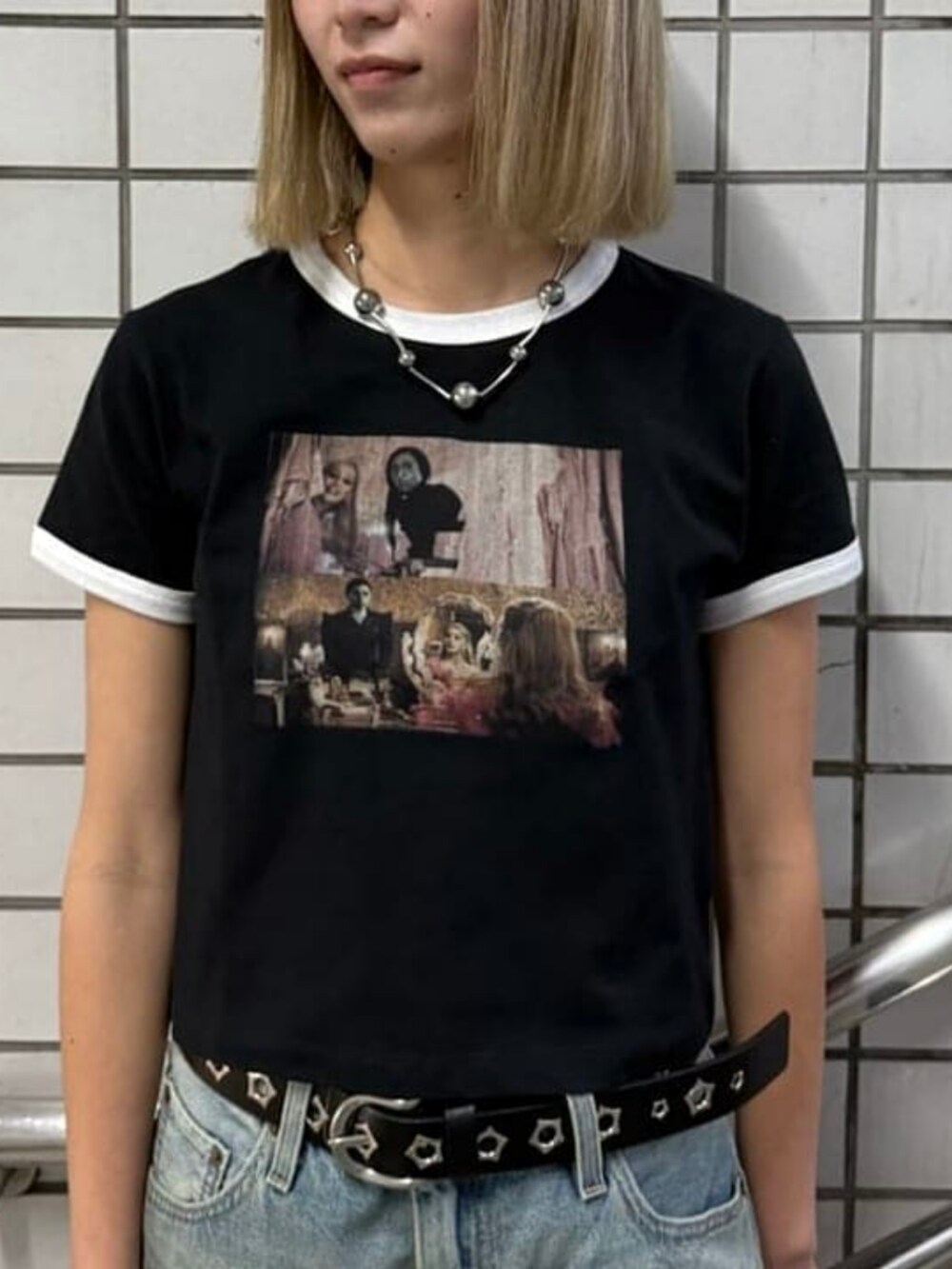 ブルー系のデニムパンツ、ブラック系のTシャツ/カットソー、ブラック系のタイツ/ストッキングを着用したレディースの春コーディネートの3枚目の写真