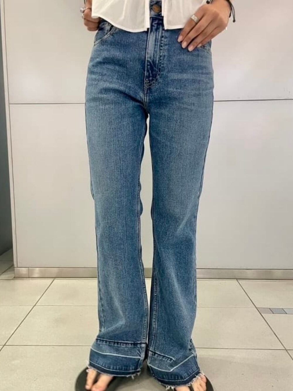 ブルー系のデニムパンツ、ホワイト系のシャツ/ブラウス、その他のトートバッグを着用したレディースの夏コーディネートの3枚目の写真