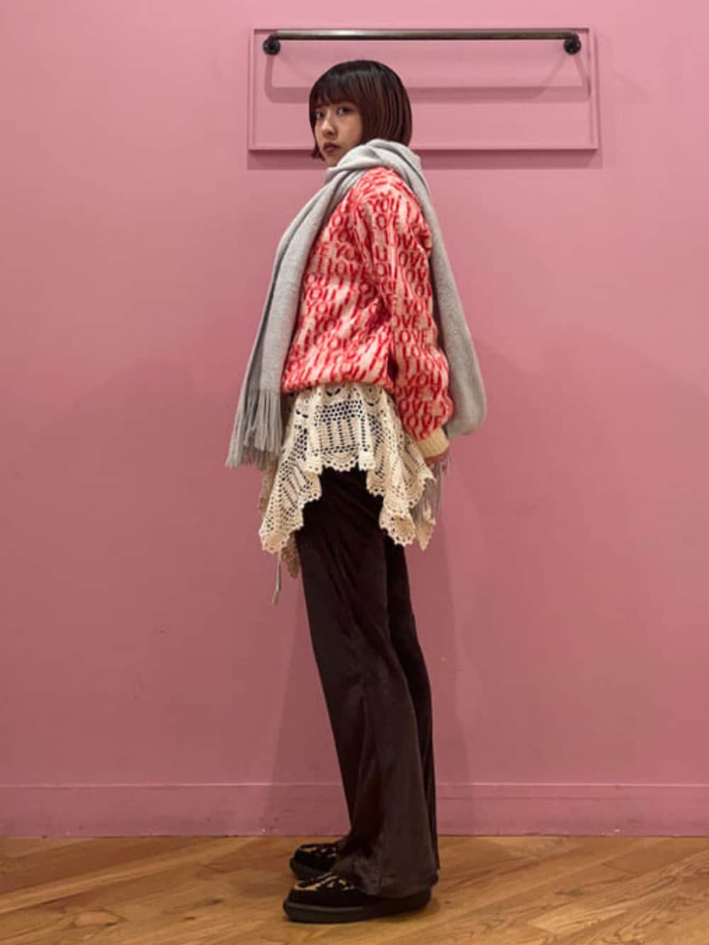 ホワイト系のニット/セーター、ブラウン系のその他パンツ、グレー系のマフラーを着用したレディースの冬コーディネートの2枚目の写真