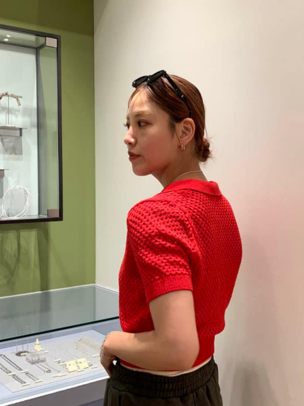 ホワイト系のトートバッグ、グレー系のスカート、レッド系のポロシャツを着用したレディースの春コーディネートの2枚目の写真