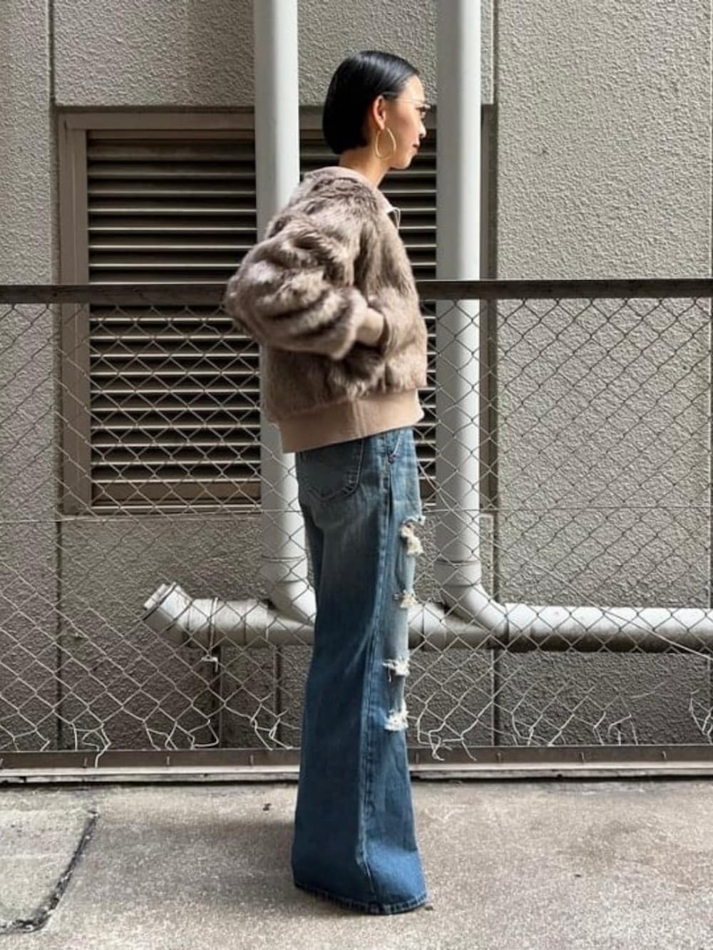 ブルー系のデニムパンツ、ブラウン系のブルゾンを着用したレディースの秋コーディネートの2枚目の写真