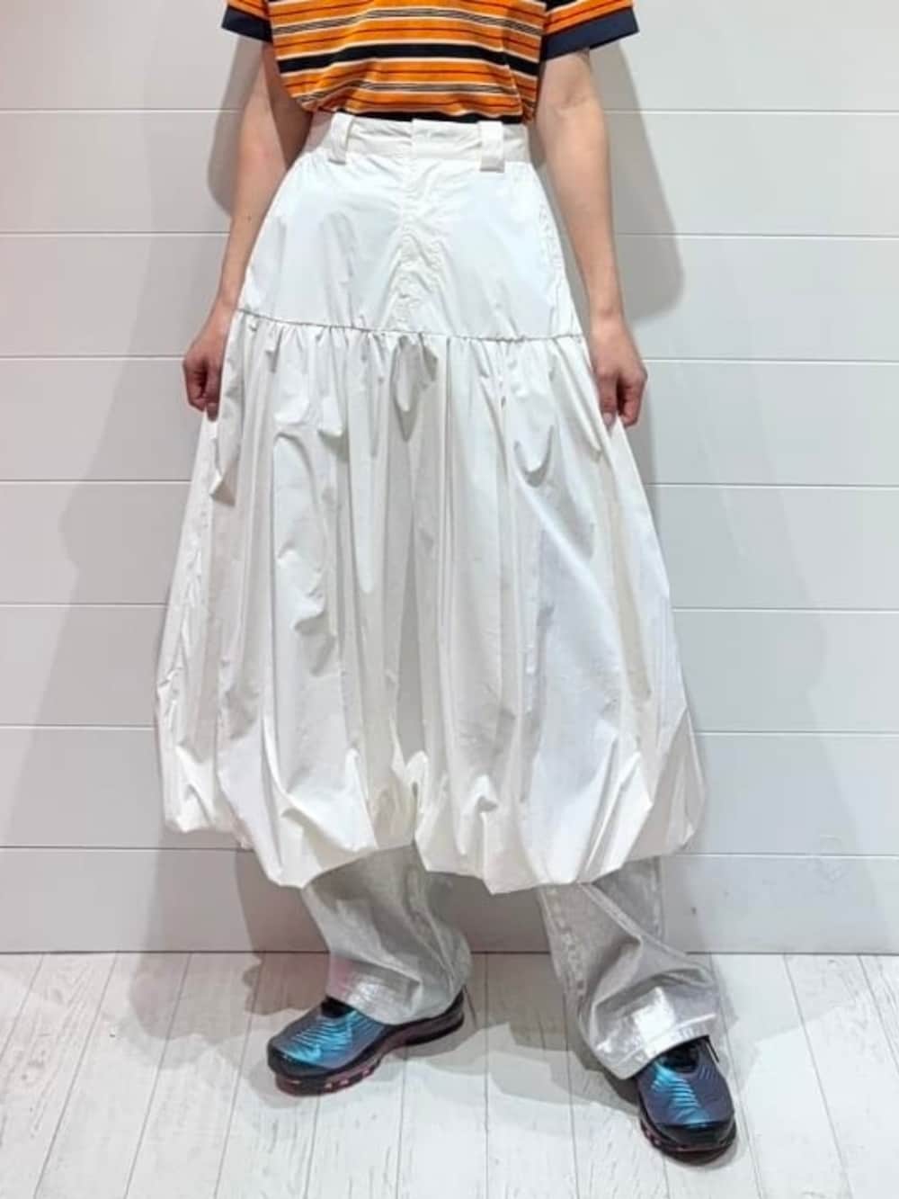 ホワイト系のデニムパンツ、ホワイト系のスカート、ブラック系のトートバッグを着用したレディースの春コーディネートの3枚目の写真