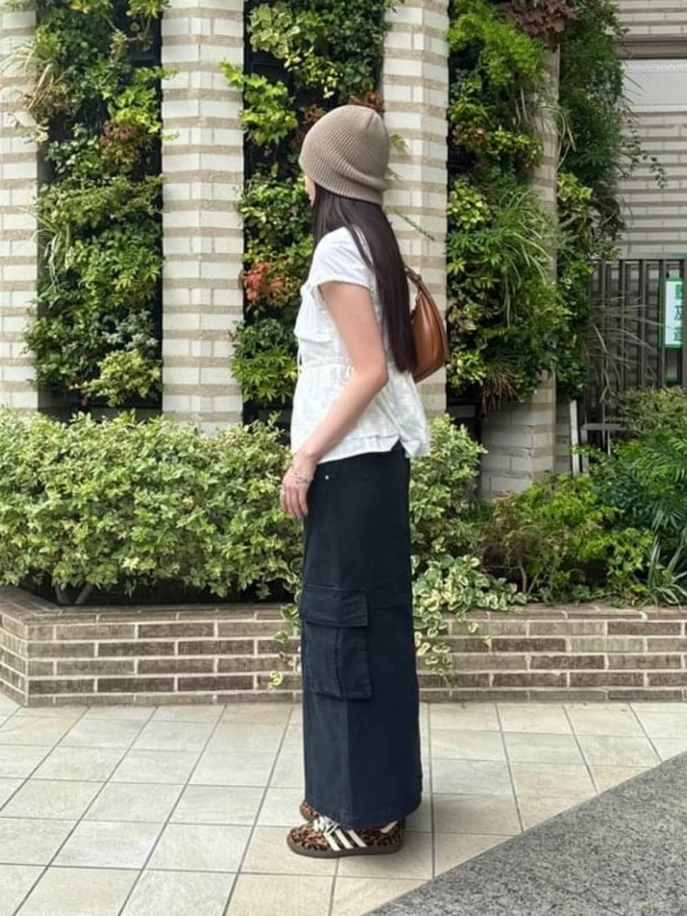 ブラウン系のトートバッグ、ホワイト系のシャツ/ブラウス、ブラック系のスカートを着用したレディースの夏コーディネートの2枚目の写真