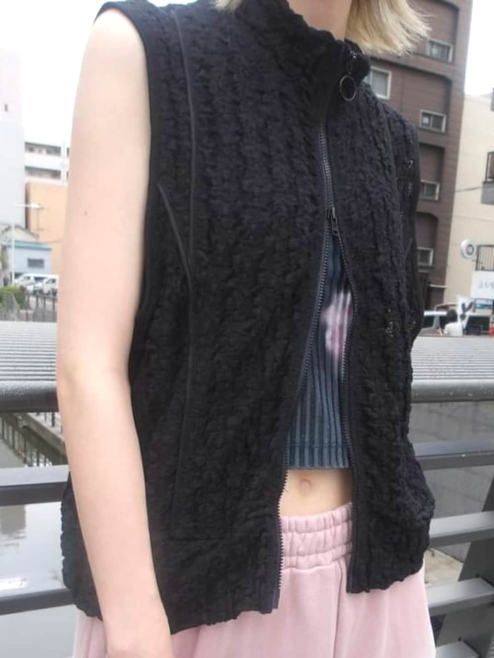 ピンク系のスウェットパンツ、ブラック系のトートバッグ、ブラック系のベストを着用したレディースの春コーディネートの2枚目の写真