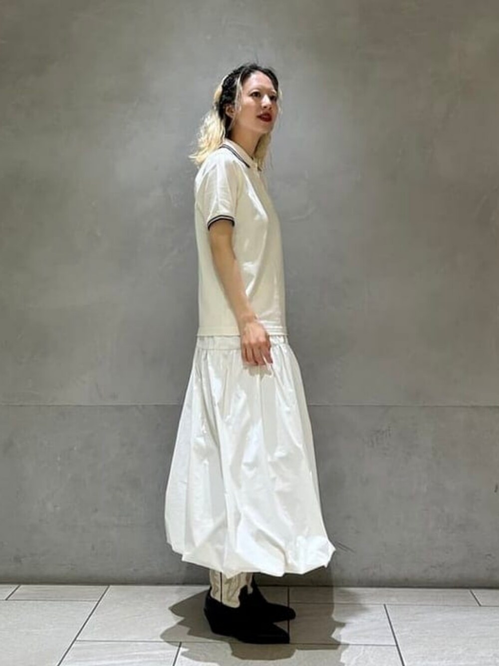 ホワイト系のスカート、ホワイト系のポロシャツを着用したレディースの夏コーディネートの2枚目の写真