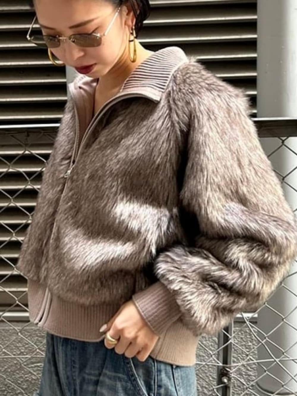 ブルー系のデニムパンツ、ブラウン系のブルゾンを着用したレディースの秋コーディネートの3枚目の写真