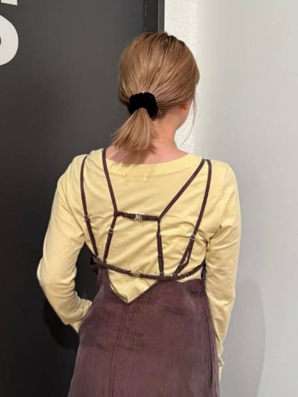 ブラウン系のワンピース、ベージュ系のTシャツ/カットソー、ホワイト系のハンドバッグを着用したレディースの春コーディネートの2枚目の写真