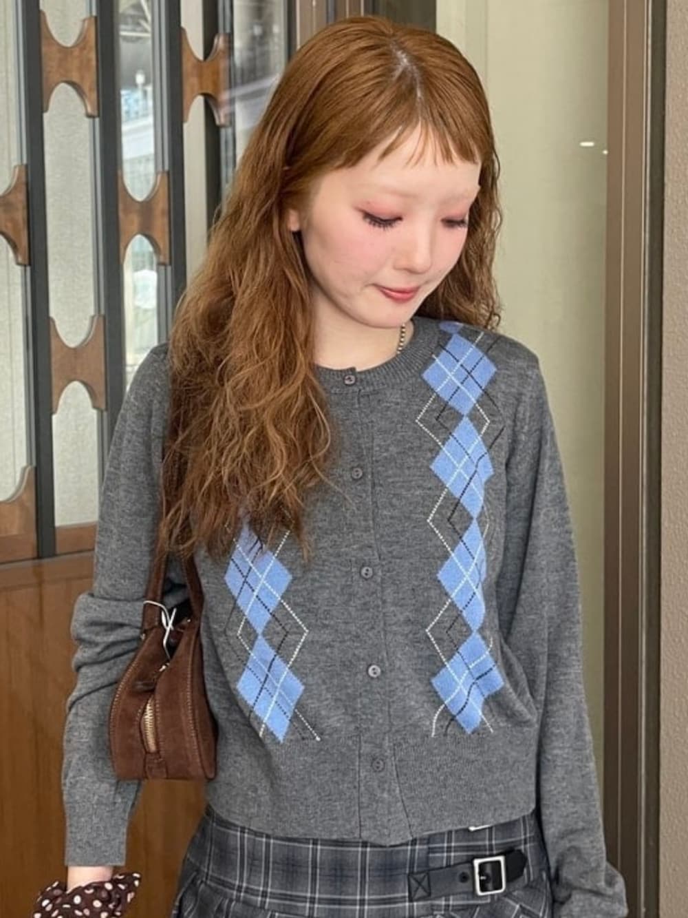 シルバー系のカーディガン/ボレロ、シルバー系のスカート、ブラウン系のトートバッグを着用したレディースの秋コーディネートの3枚目の写真