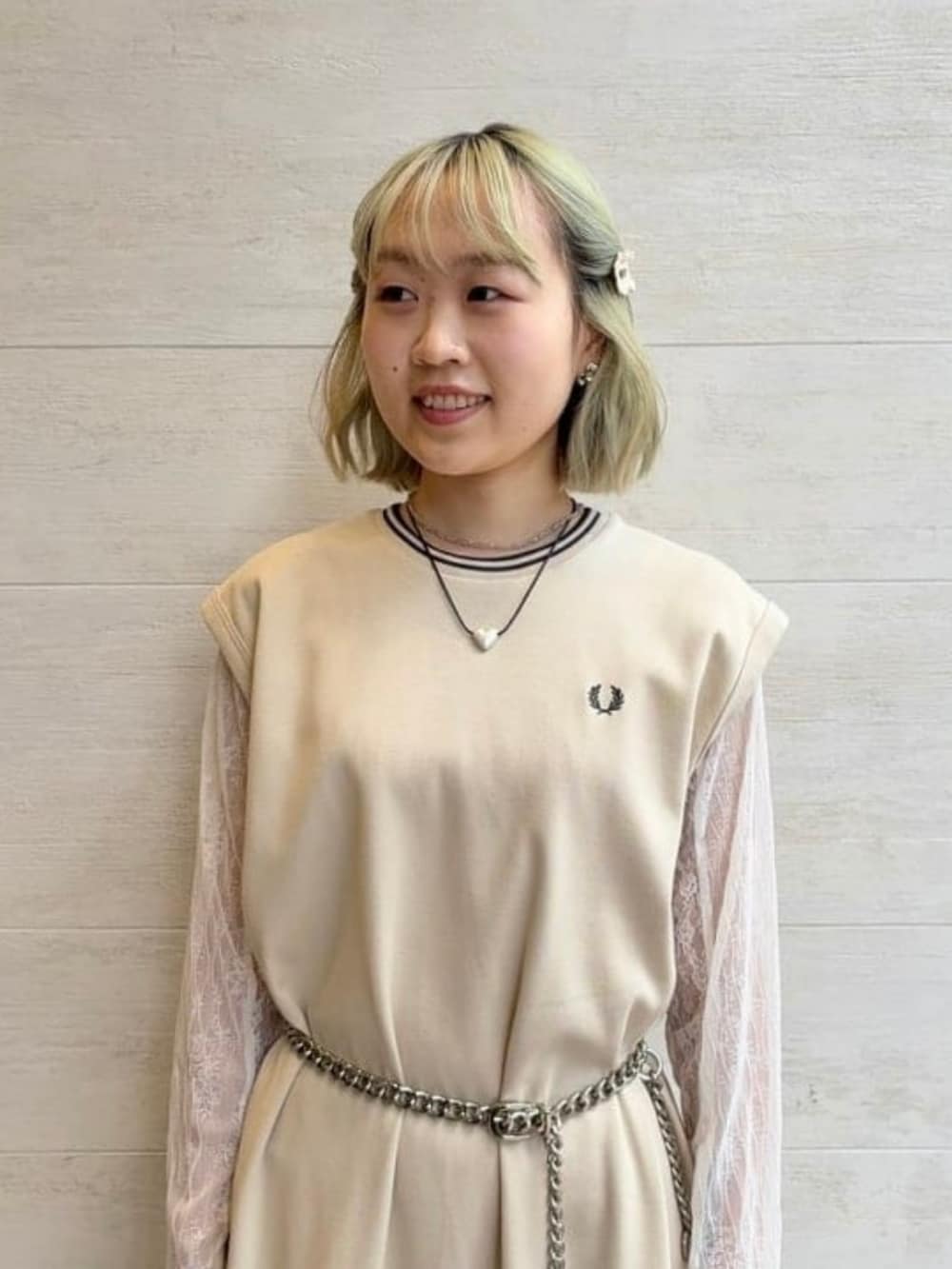 ベージュ系のワンピース、ホワイト系のTシャツ/カットソー、シルバー系のポーチを着用したレディースの春コーディネートの2枚目の写真