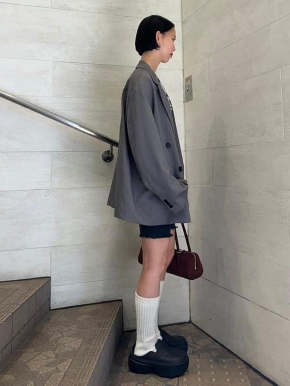 ブラウン系のトートバッグ、グレー系のカーディガン/ボレロ、グレー系のテーラードジャケットを着用したレディースの秋コーディネートの3枚目の写真