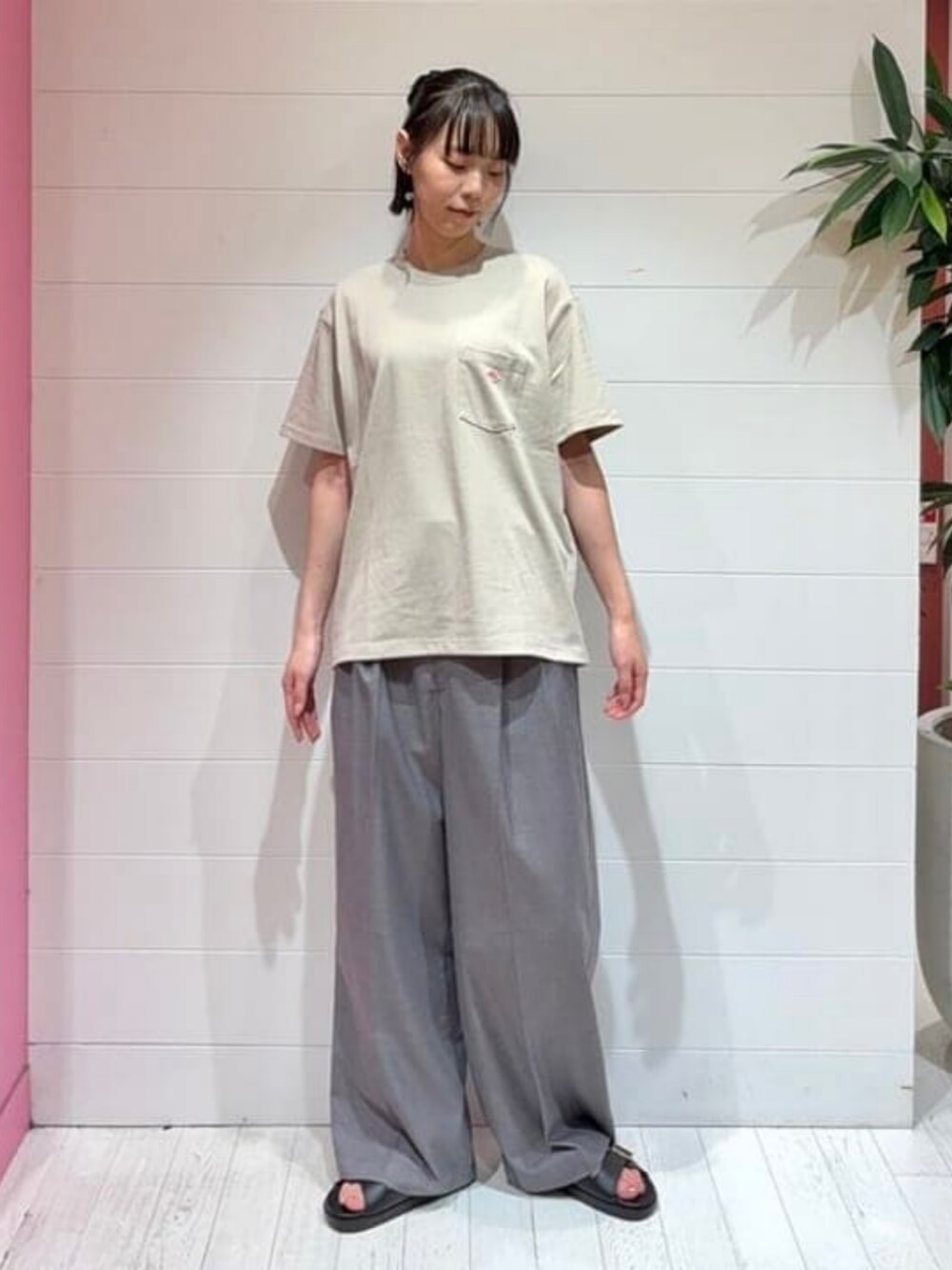 ブラック系のトートバッグ、ブラック系のサンダル、ベージュ系のTシャツ/カットソーを着用したレディースの夏コーディネートの3枚目の写真