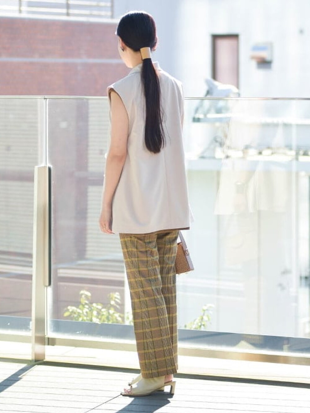 ベージュ系のベスト、ベージュ系のその他パンツ、グリーン系のTシャツ/カットソーを着用したレディースの春コーディネートの2枚目の写真