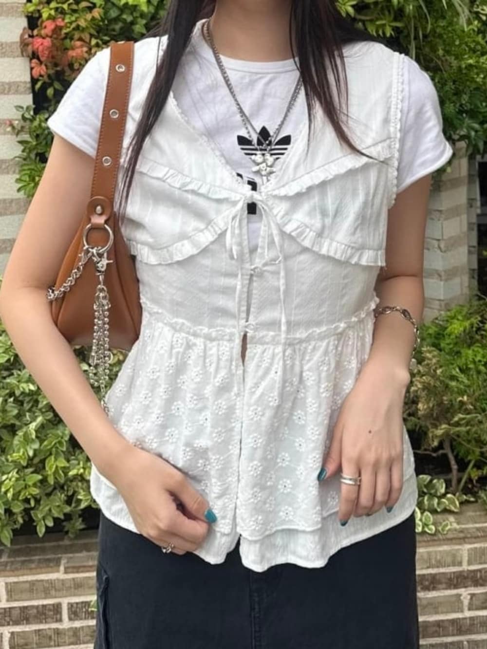 ブラウン系のトートバッグ、ホワイト系のシャツ/ブラウス、ブラック系のスカートを着用したレディースの夏コーディネートの3枚目の写真