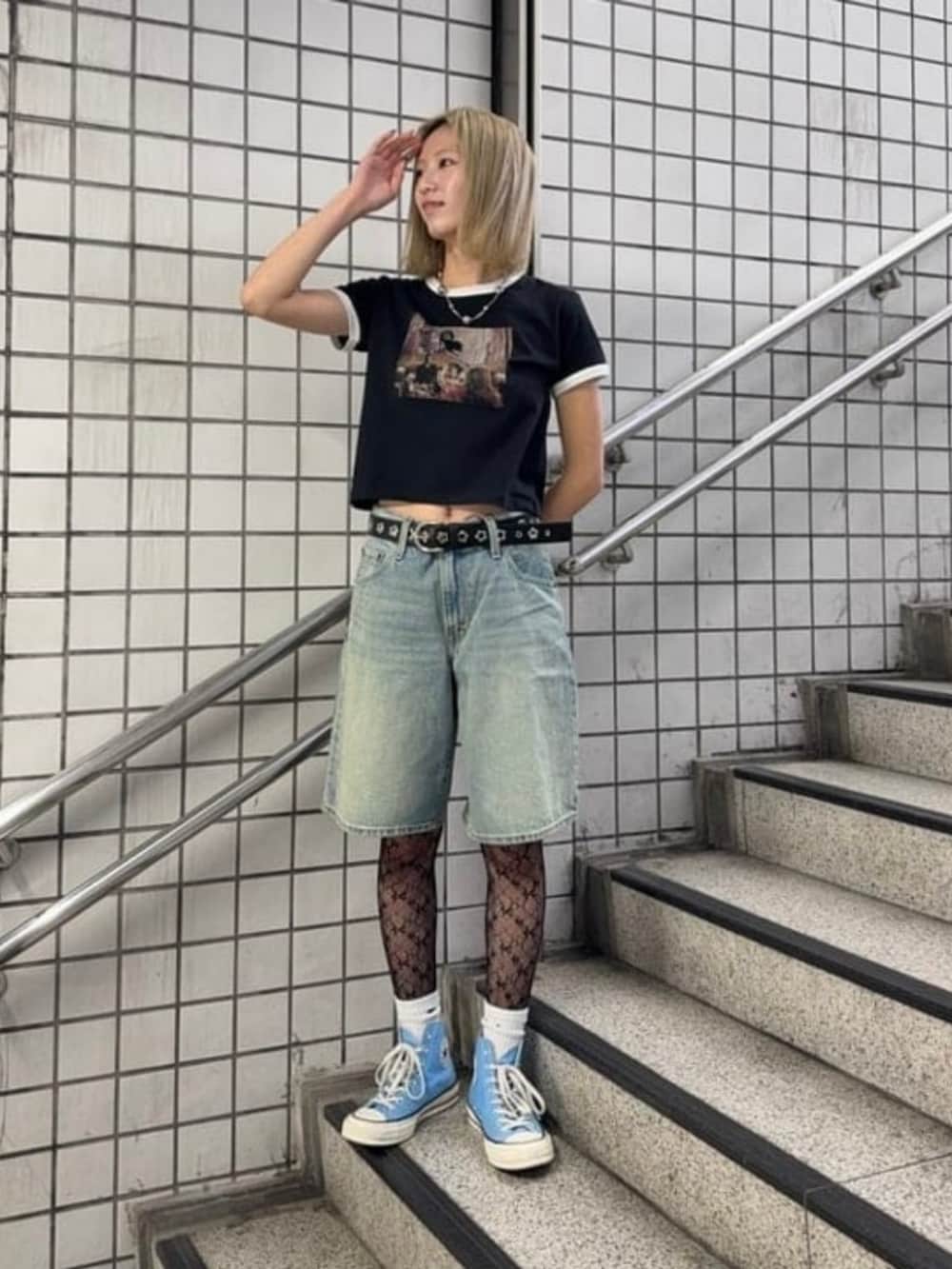 ブルー系のデニムパンツ、ブラック系のTシャツ/カットソー、ブラック系のタイツ/ストッキングを着用したレディースの春コーディネートの4枚目の写真