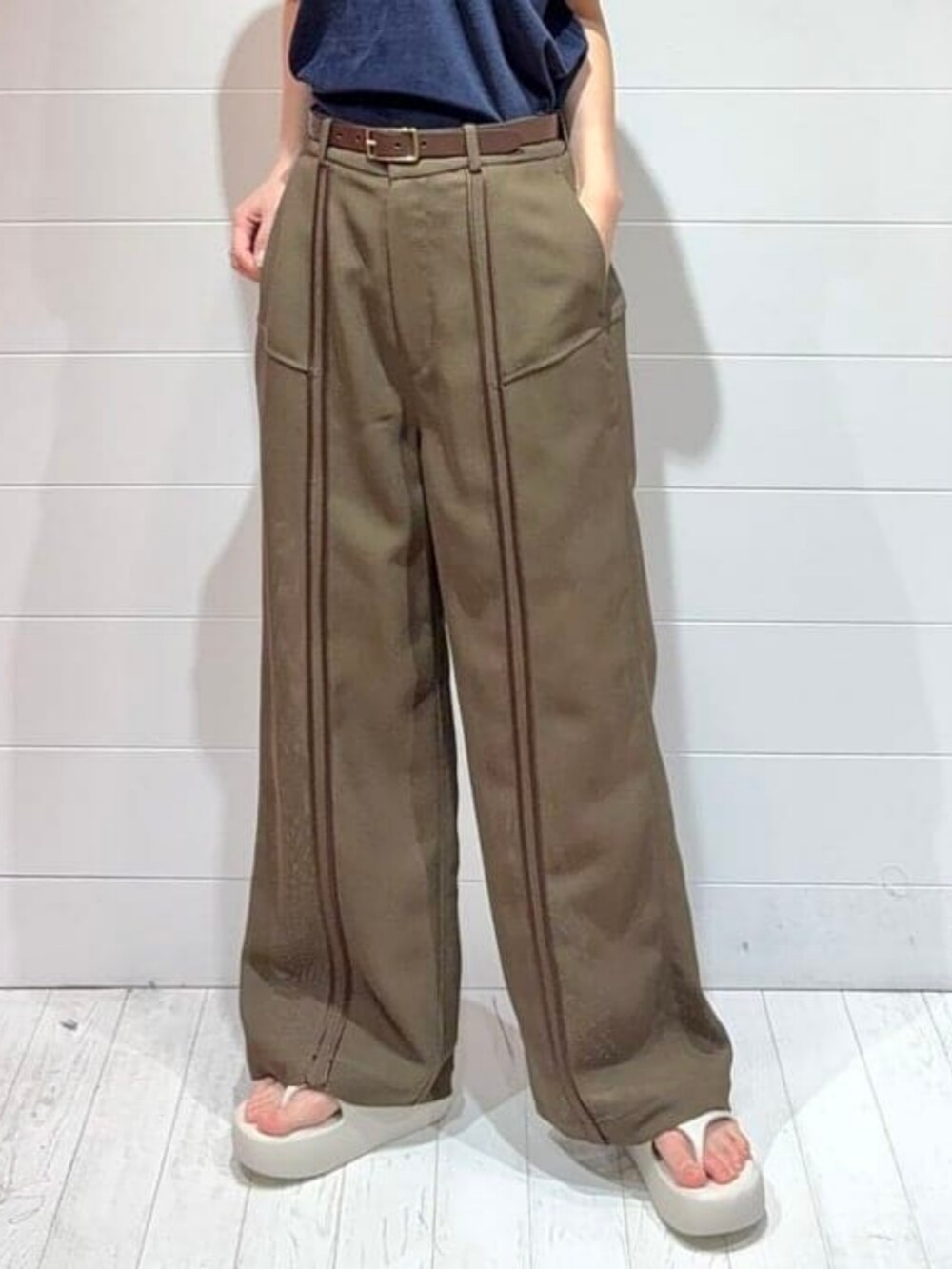 ブルー系のポロシャツ、ブラウン系のその他パンツを着用したレディースの夏コーディネートの4枚目の写真