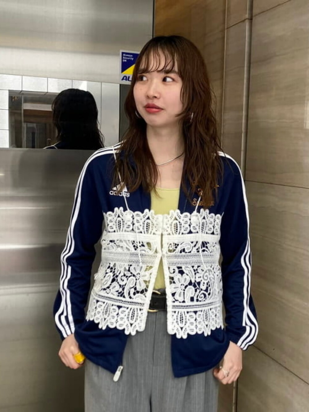 ブラウン系のハンドバッグ、ブラック系のドレスシューズ、ホワイト系のキャミソールを着用したレディースの春コーディネートの3枚目の写真