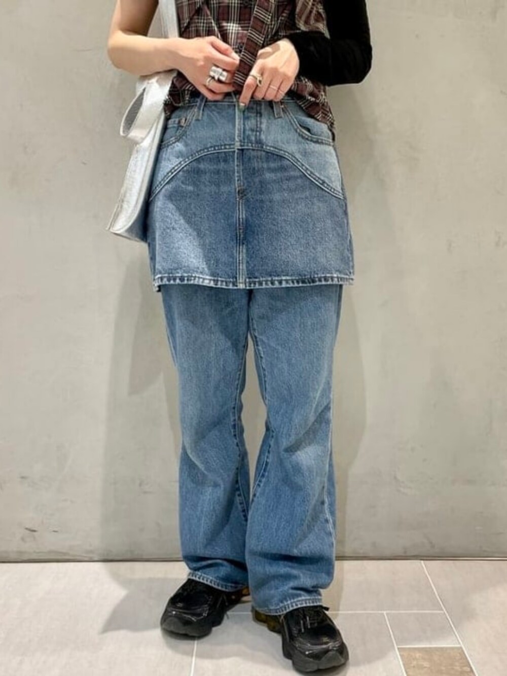 ブラウン系のシャツ/ブラウス、グレー系のTシャツ/カットソー、ブルー系のデニムスカートを着用したレディースの春コーディネートの3枚目の写真