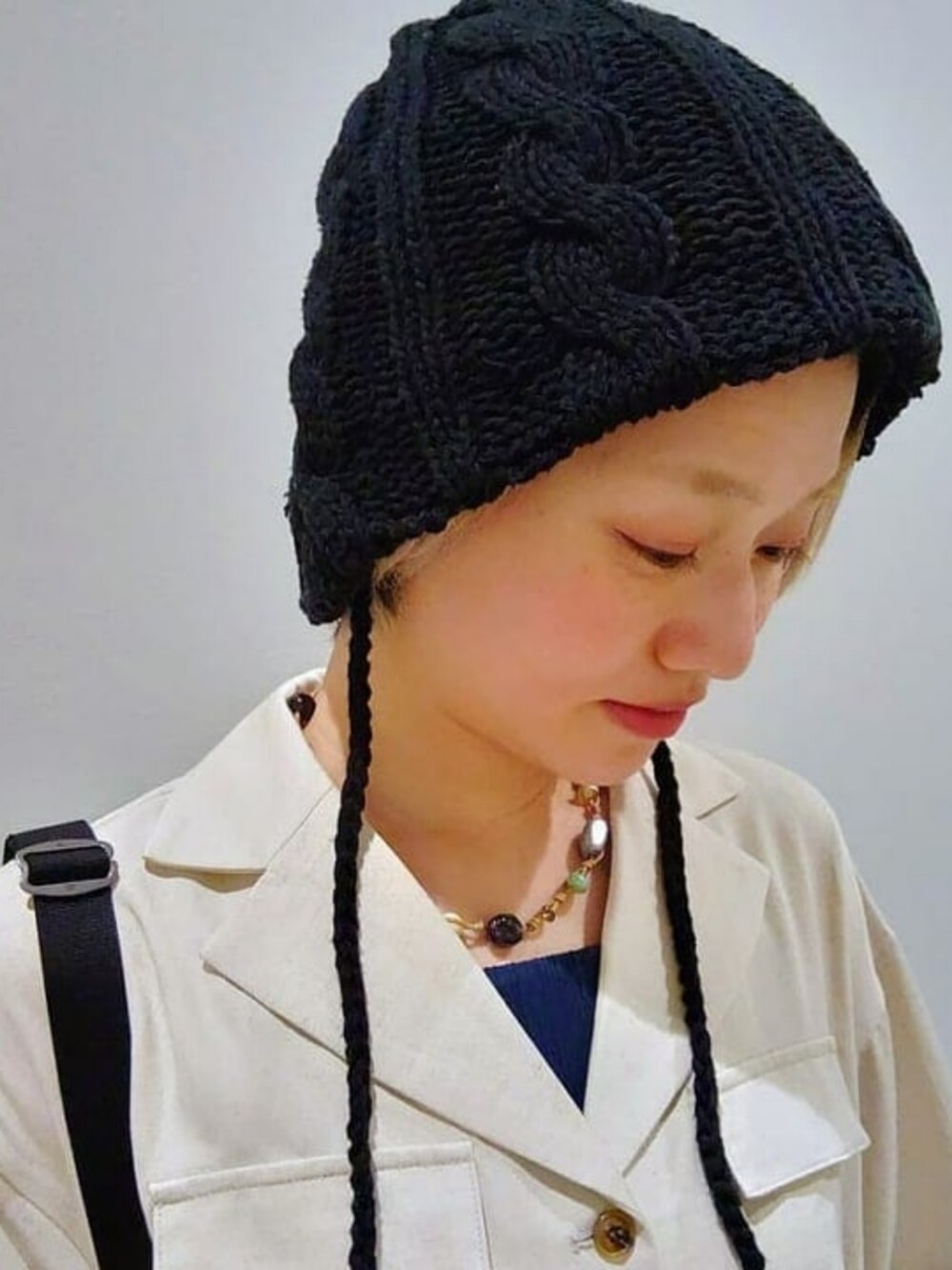 ホワイト系のワンピース、ブラック系のショルダーバッグ、ブラック系のハットを着用したレディースの春コーディネートの3枚目の写真