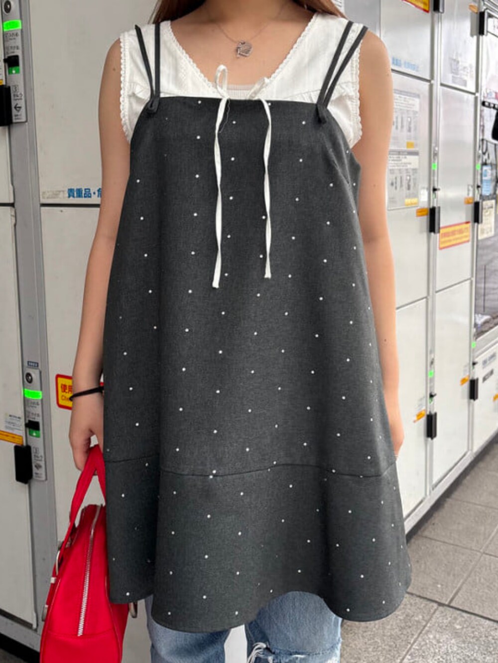 レッド系のボストンバッグ、グレー系のワンピース、ホワイト系のシャツ/ブラウスを着用したレディースの夏コーディネートの3枚目の写真