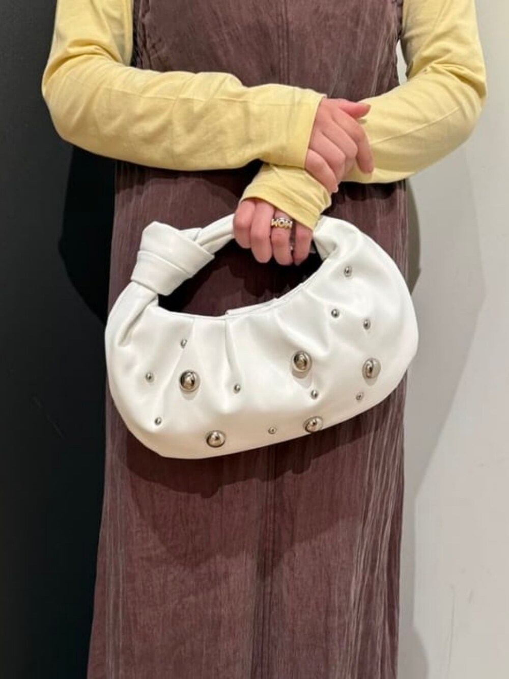 ブラウン系のワンピース、ベージュ系のTシャツ/カットソー、ホワイト系のハンドバッグを着用したレディースの春コーディネートの4枚目の写真