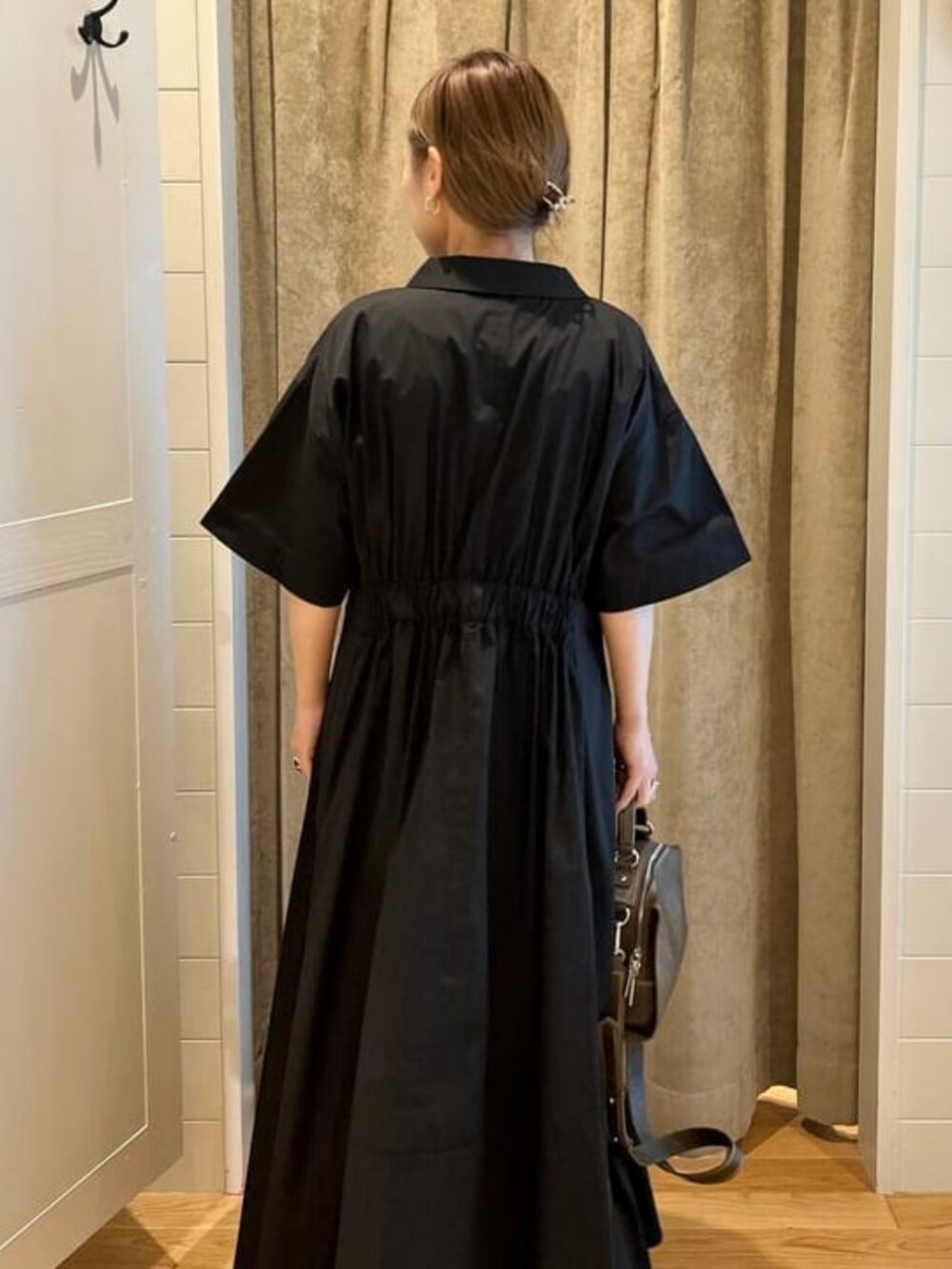 ブラウン系のテーラードジャケット、ブラウン系のハンドバッグ、ブラック系のワンピースを着用したレディースの春コーディネートの3枚目の写真