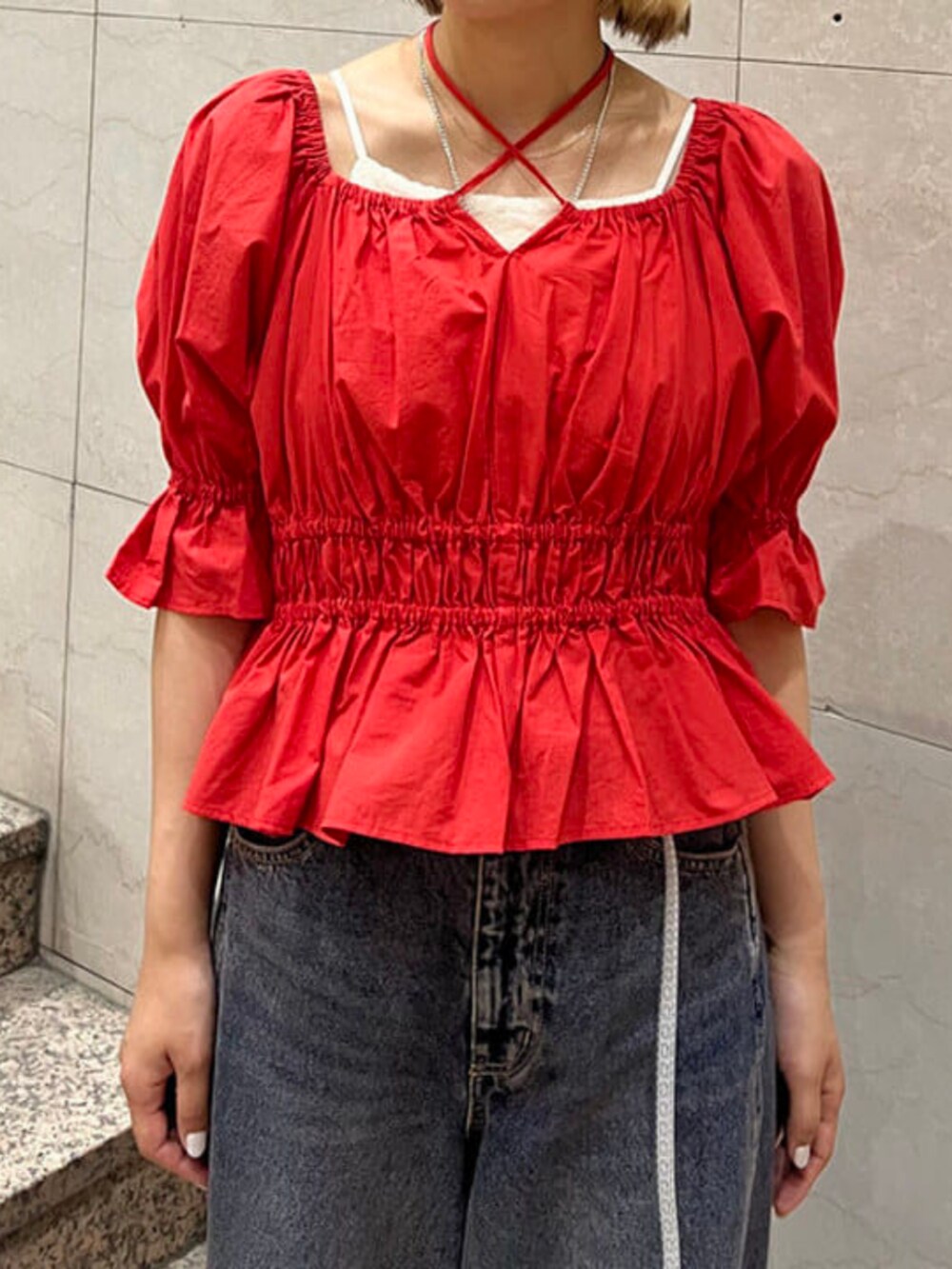 ブルー系のデニムパンツ、ホワイト系のキャミソール、レッド系のシャツ/ブラウスを着用したレディースの春コーディネートの3枚目の写真