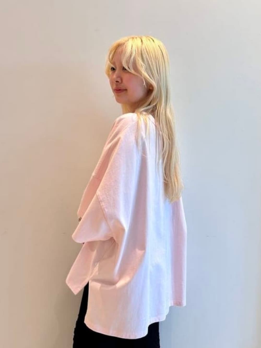 ブラック系のショルダーバッグ、ピンク系のTシャツ/カットソー、ブラック系のスカートを着用したレディースの春コーディネートの3枚目の写真