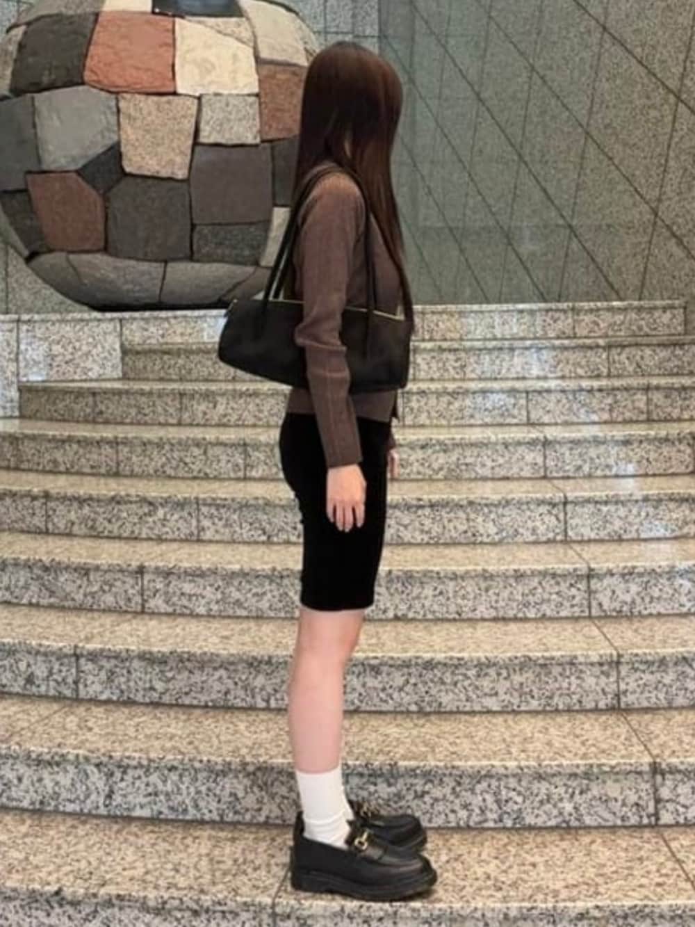 ブラック系のその他パンツ、ブラック系のトートバッグ、ブラウン系のニット/セーターを着用したレディースの秋コーディネートの2枚目の写真