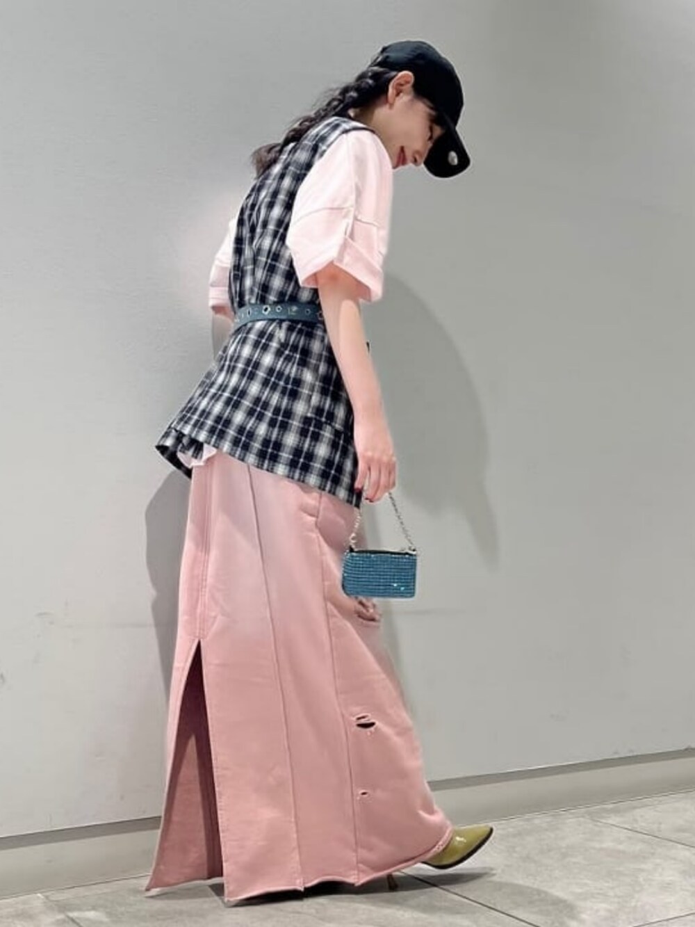 ピンク系のスカート、ピンク系のTシャツ/カットソー、ブラック系のベストを着用したレディースの夏コーディネートの2枚目の写真