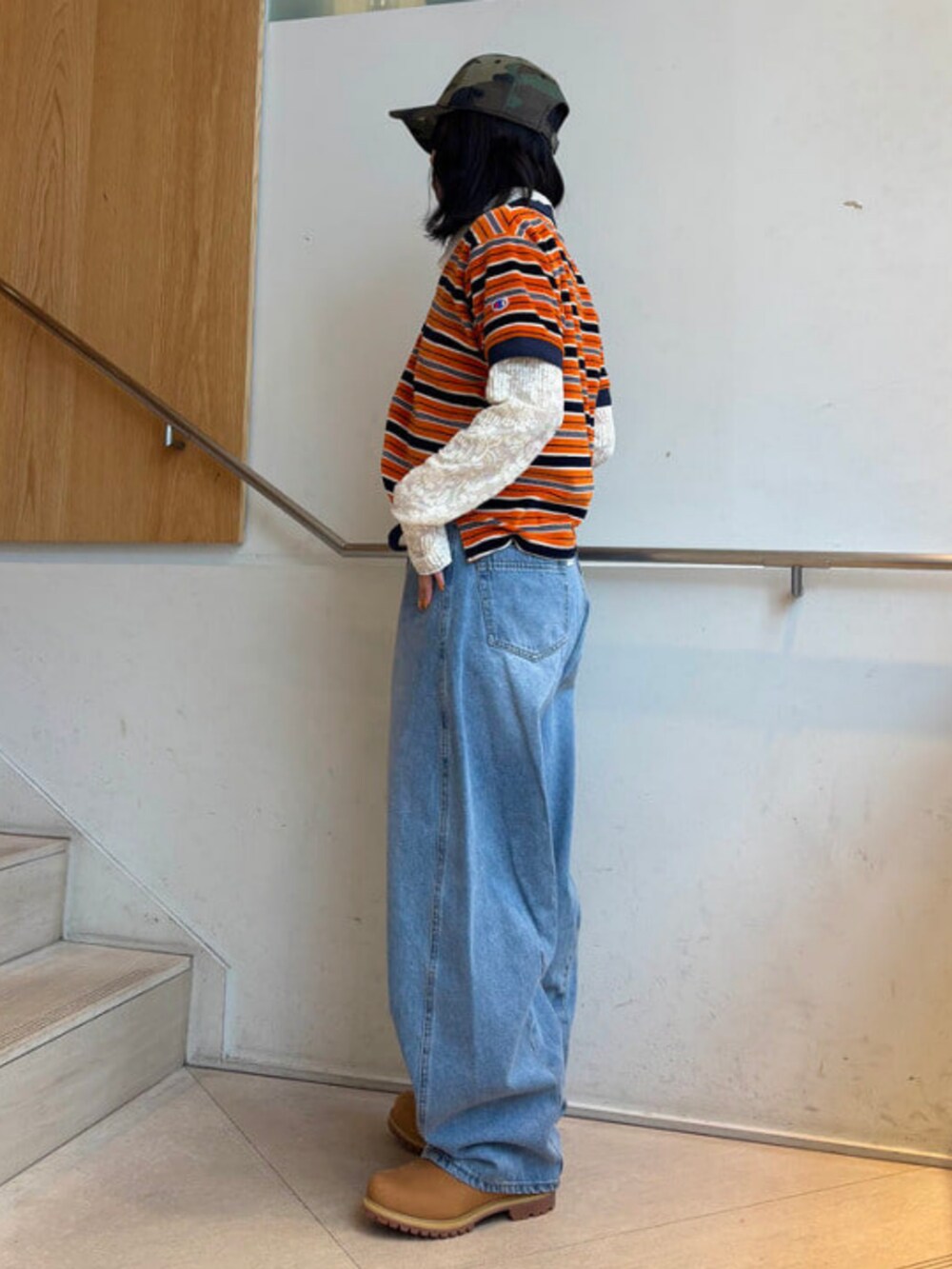 ホワイト系のシャツ/ブラウス、ブルー系のデニムパンツ、オレンジ系のポロシャツを着用したレディースの春コーディネートの2枚目の写真