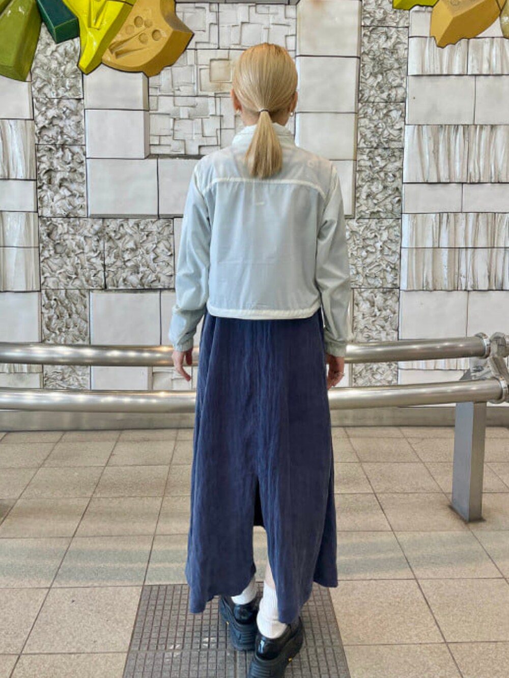 ベージュ系のナイロンジャケット、ブルー系のTシャツ/カットソー、ブルー系のワンピースを着用したレディースの春コーディネートの3枚目の写真