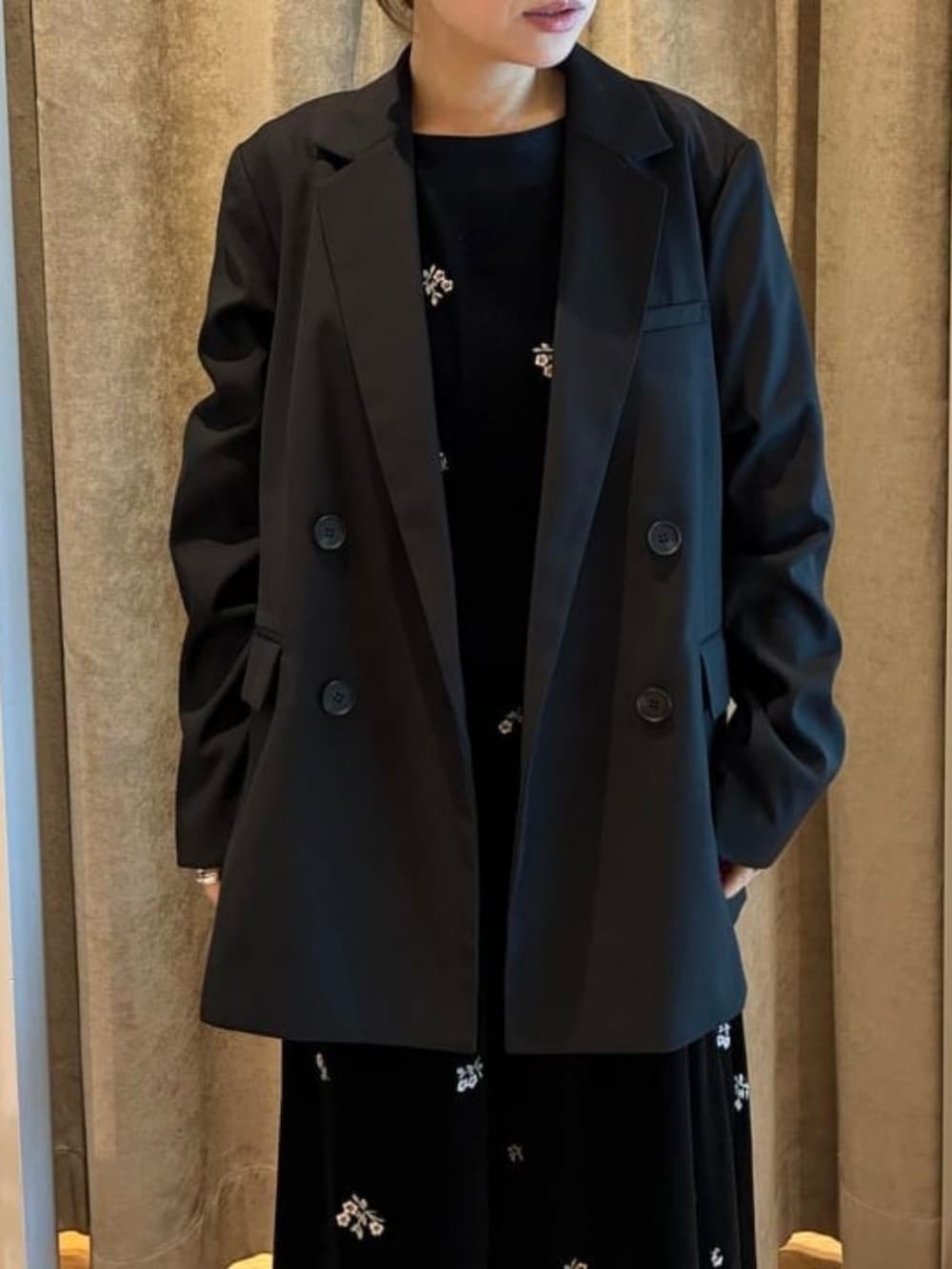 ブラック系のテーラードジャケット、ブラック系のワンピースを着用したレディースの秋コーディネートの2枚目の写真