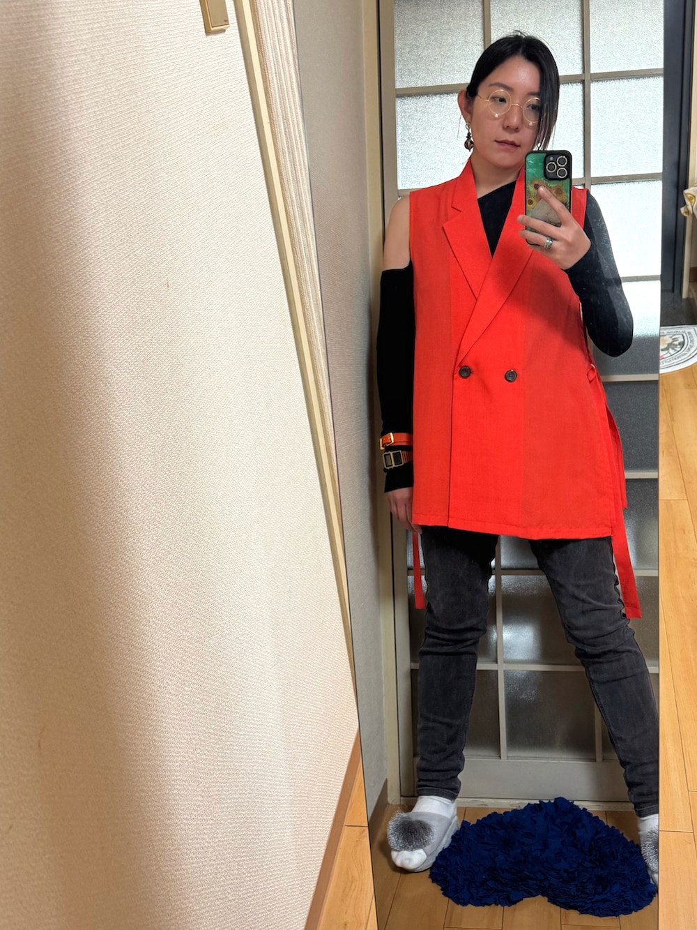 オレンジ系のベストを着用したレディースの夏コーディネートの2枚目の写真