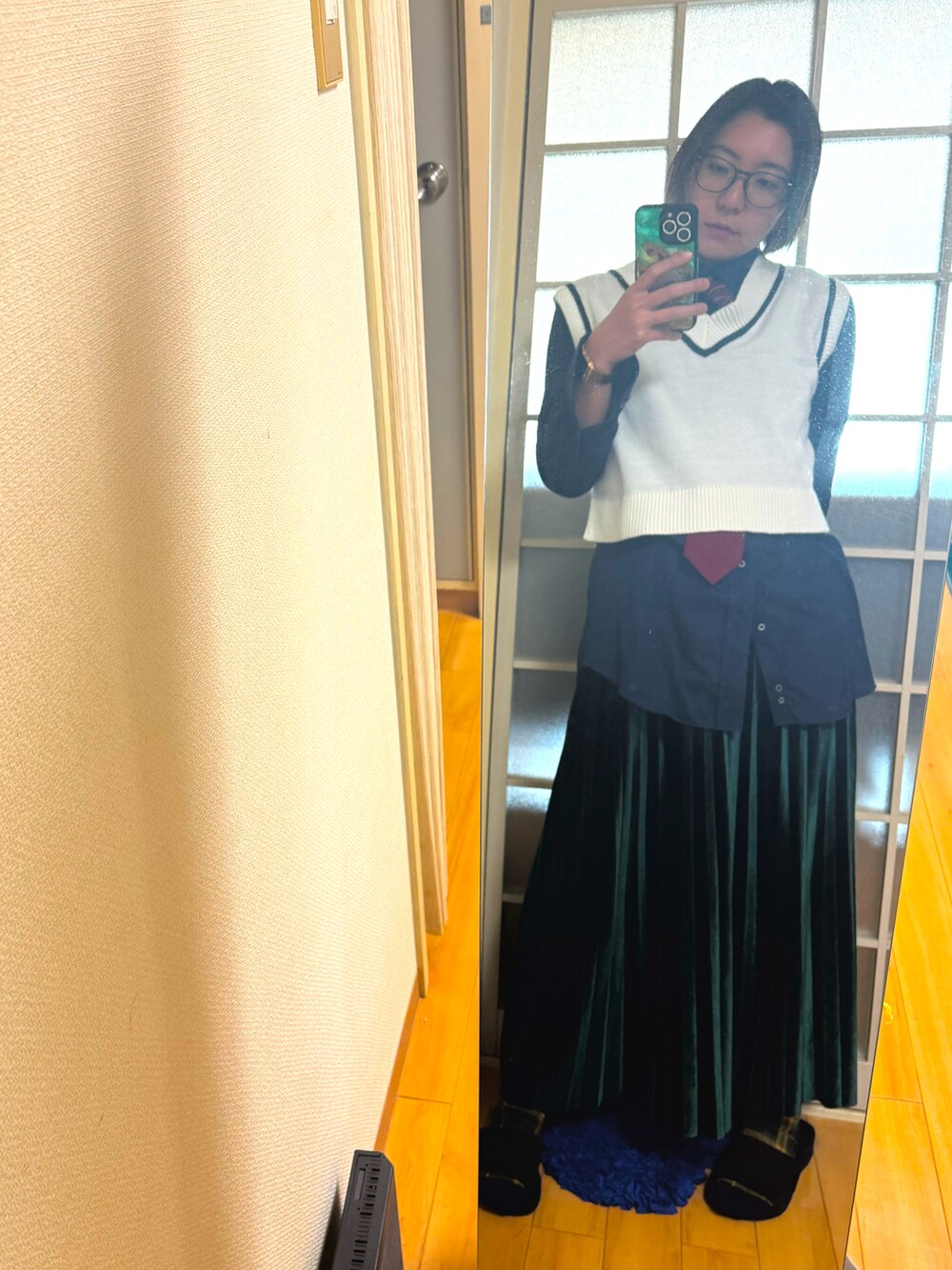 グリーン系のスカート、ブラック系のドレスシューズを着用したレディースの冬コーディネートの2枚目の写真