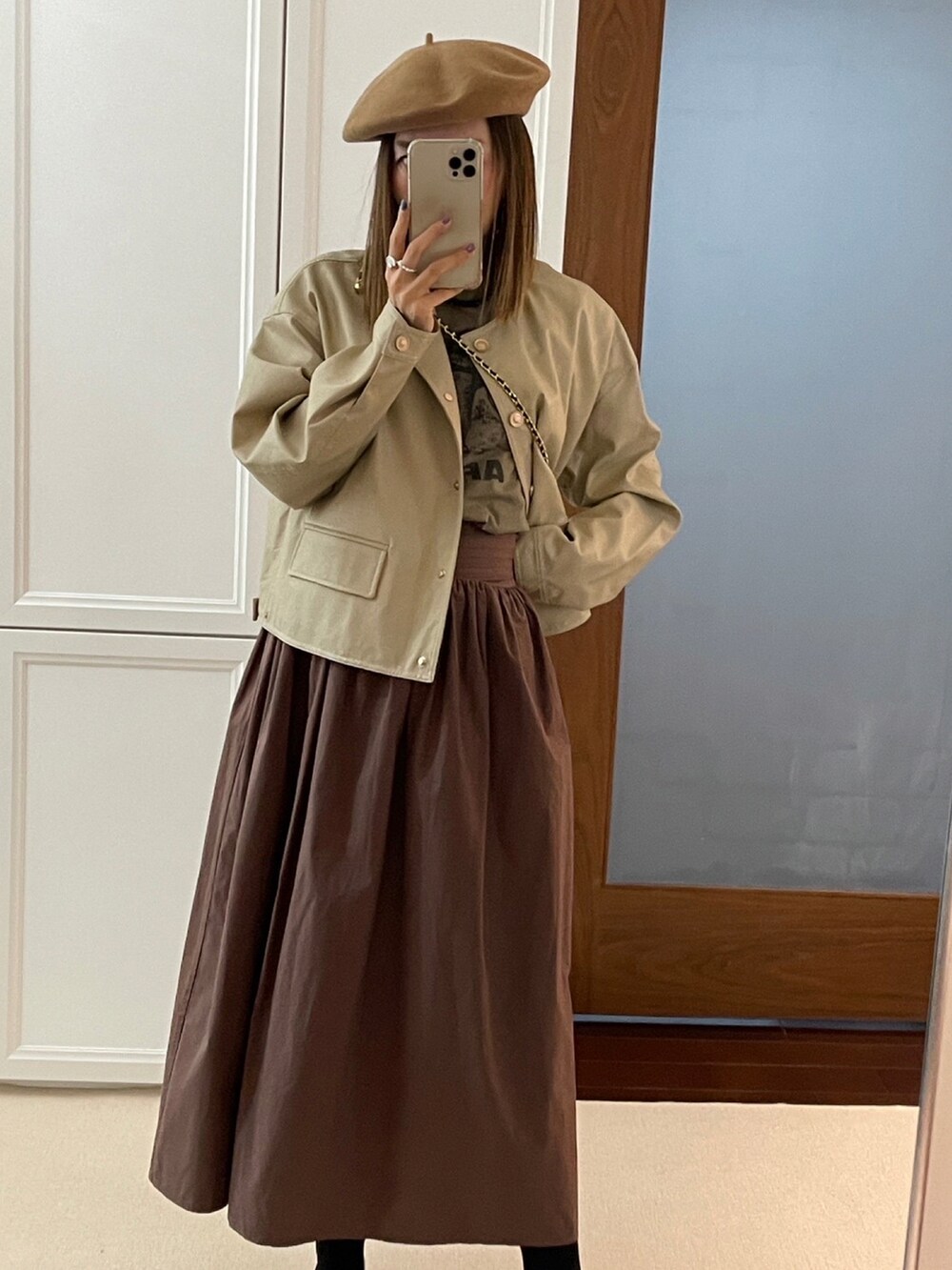 ベージュ系のトップスを着用したレディースの秋コーディネートの2枚目の写真