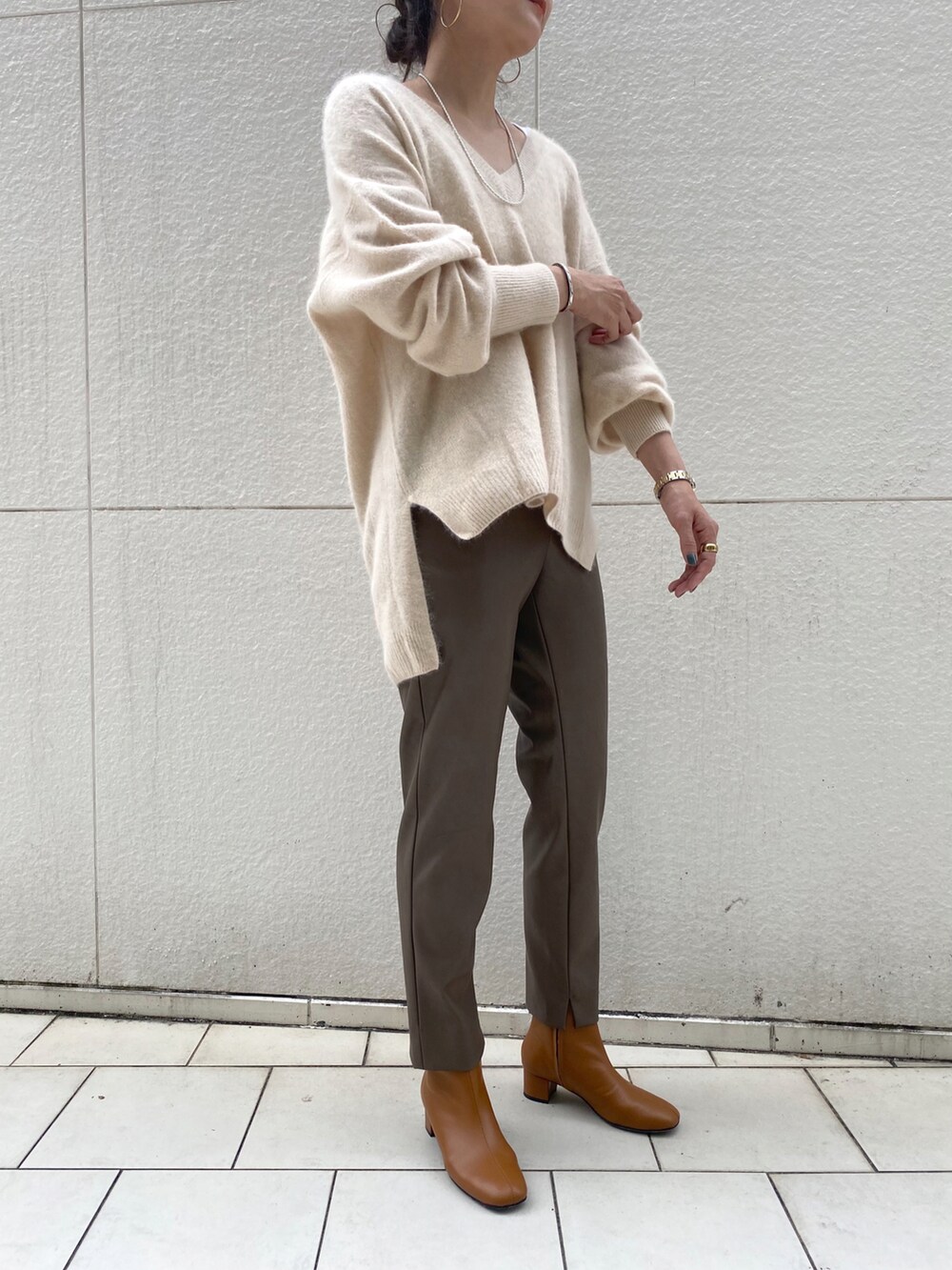 ホワイト系のニット/セーター、グレー系のその他パンツ、ホワイト系のブーティを着用したレディースの秋コーディネートの2枚目の写真