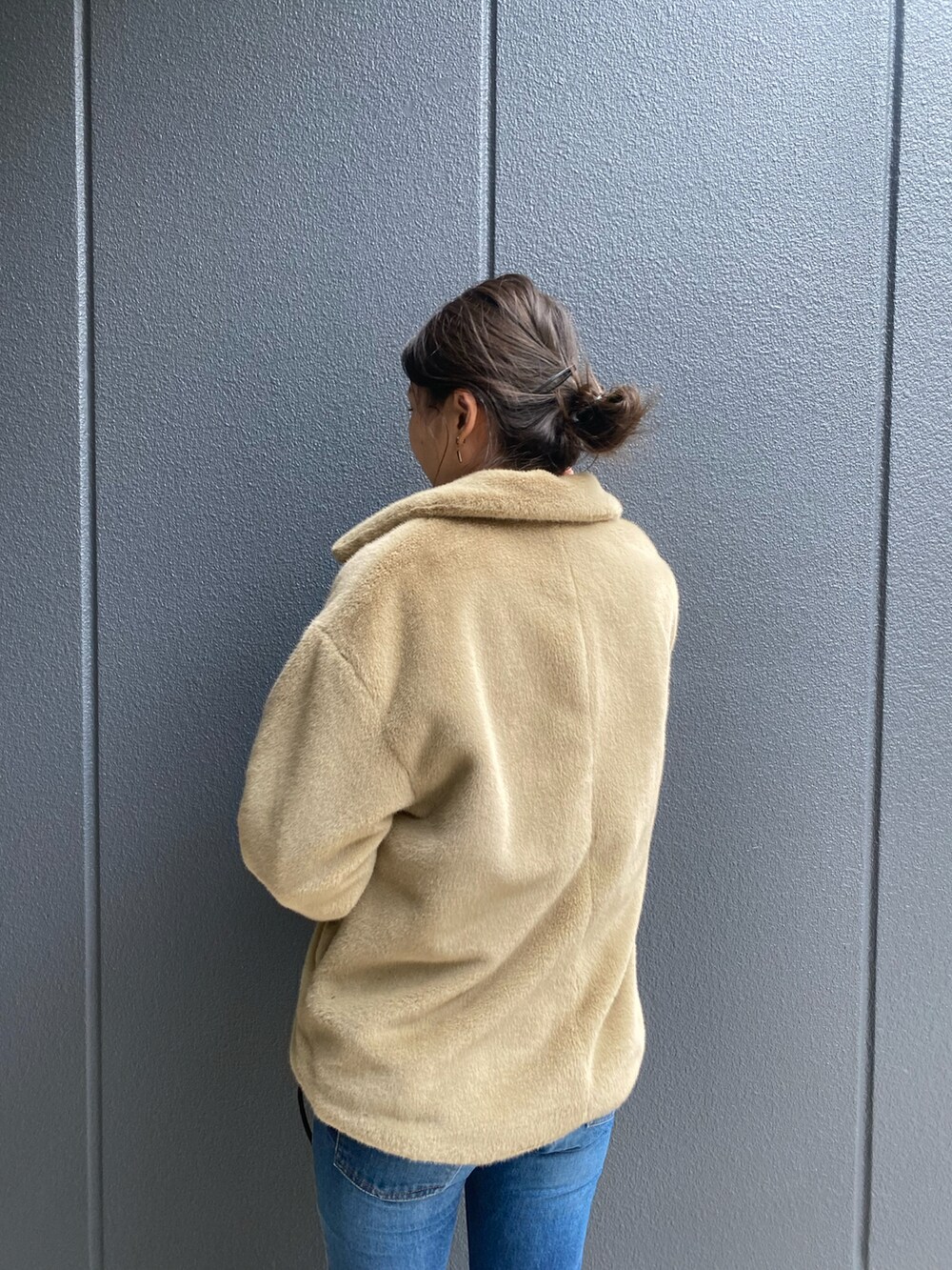ブルー系のデニムパンツ、ベージュ系のその他アウター、ブラック系のトートバッグを着用したレディースの秋コーディネートの2枚目の写真