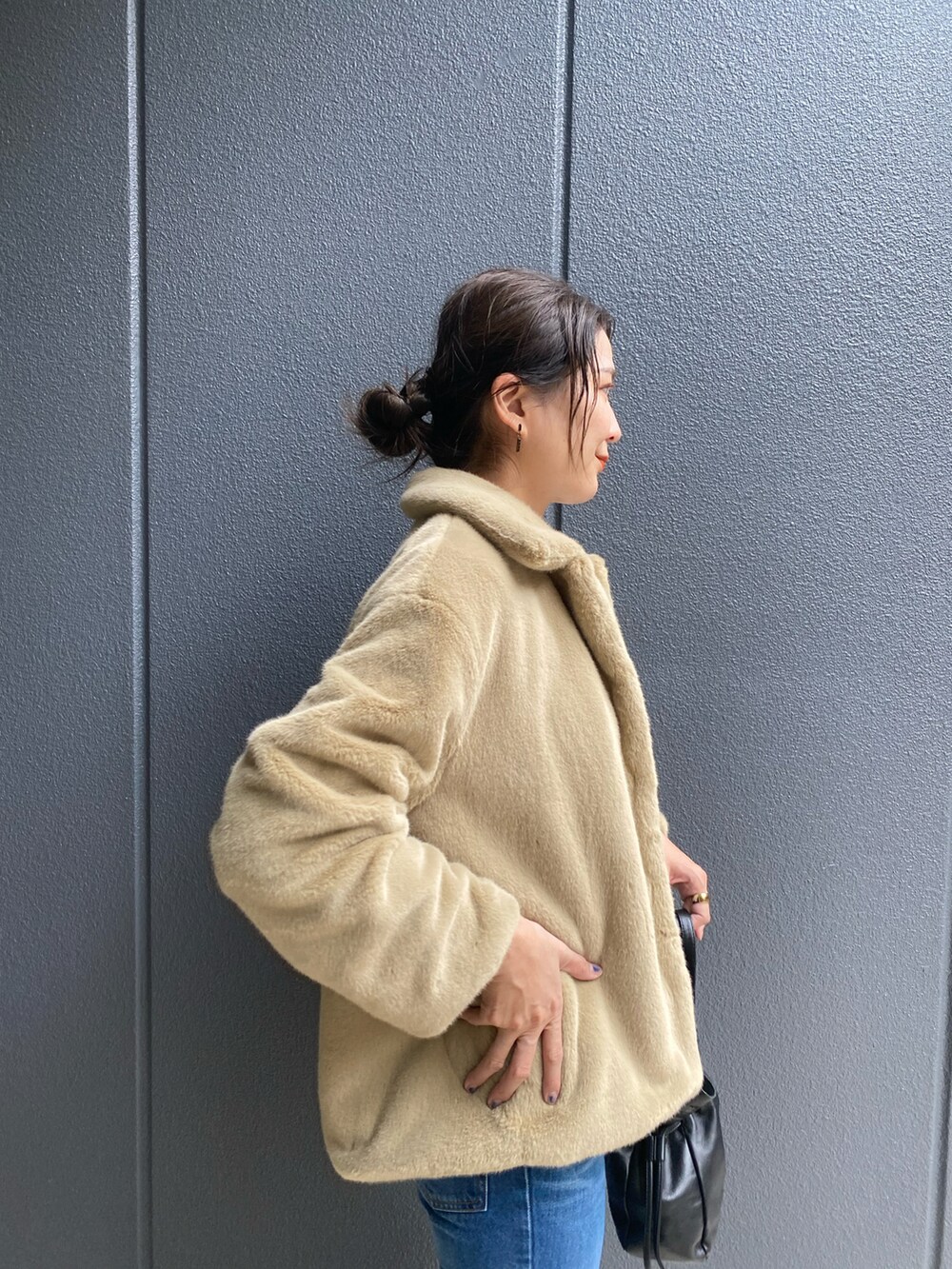 ブルー系のデニムパンツ、ベージュ系のその他アウター、ブラック系のトートバッグを着用したレディースの秋コーディネートの3枚目の写真