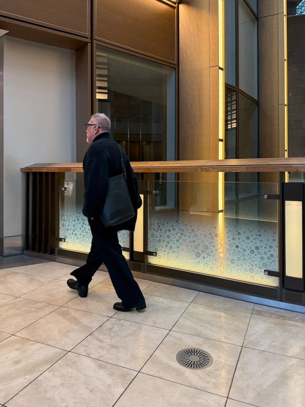 ブラック系のショルダーバッグ、ブラック系のカーディガン/ボレロ、ブラック系のスラックスを着用したメンズの冬コーディネートの4枚目の写真