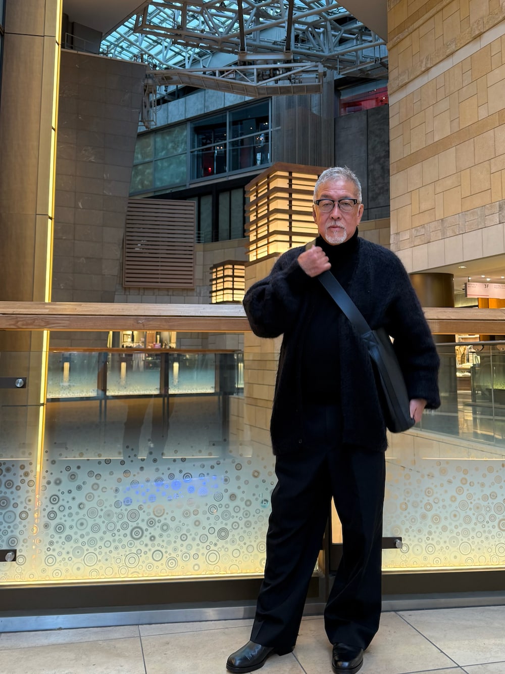 ブラック系のショルダーバッグ、ブラック系のカーディガン/ボレロ、ブラック系のスラックスを着用したメンズの冬コーディネートの5枚目の写真